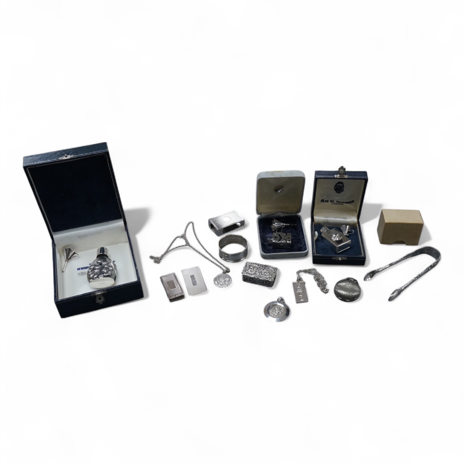 A group of mainly modern silver collectables including three assorted scent flasks and funnels by Ari D. Norman, two money clips, matchbox sleeve, napkin ring, pill box, three pendants including ingot and a pair of Victo